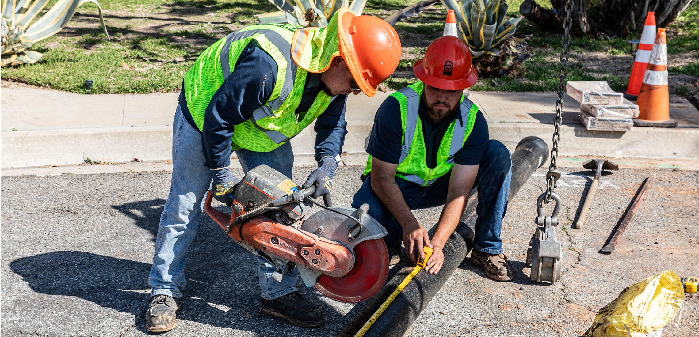 Men cutting a mainline with a saw