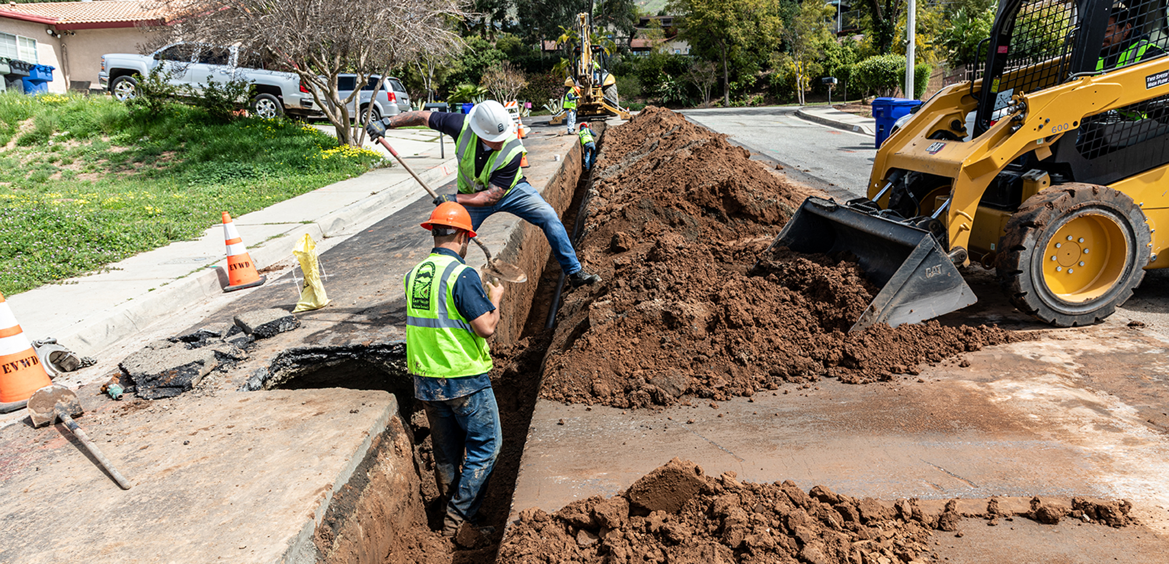 Men filling a mainline hole with shovel